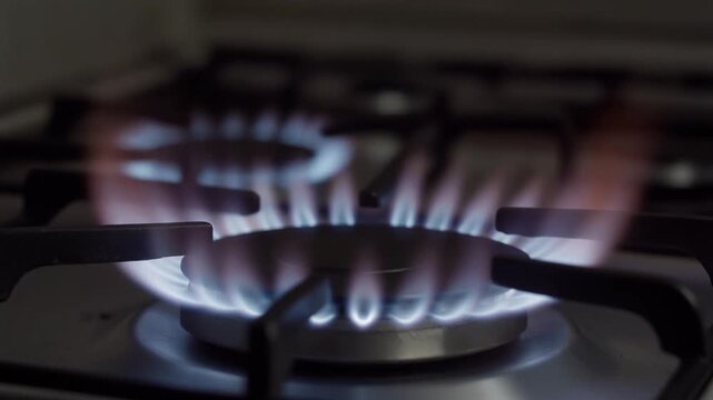 closeup slow motion of flame igniting on stove with dramatic lighting