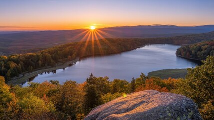 Aerial view of lake surrounded by forest with sunset and rock in the foreground beauty of nature