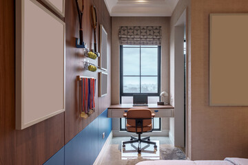 Fototapeta premium Modern study nook area featuring tennis themed decor, medals, window, and a laptop on the desk.