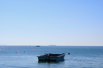 Naklejka premium An island that looks small in the distance and a boat that you see right in front of you