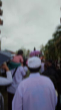 Blurry footage showing Hindu devotees entering a temple gate during a crowded ceremony. Out of focus lens effect creating an abstract, spiritual, and cultural atmosphere.