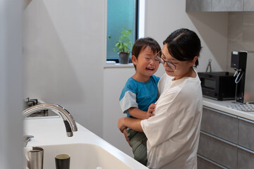 子どもが泣いて家事が出来ずイライラしているママ