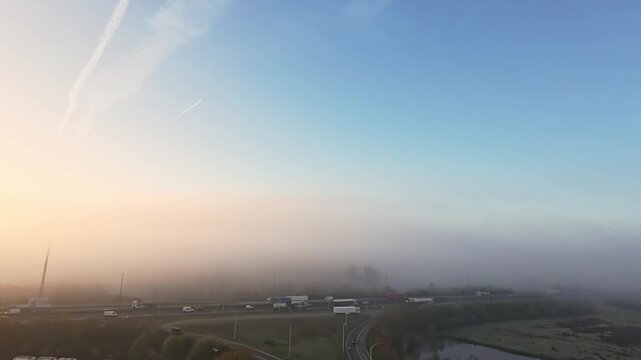 morning fogscape gradually, soft morning glow shrouds distant scenery, veiled roads and fields under serene morning mist, faint cloud trails and silent factories disappear into muted dawn