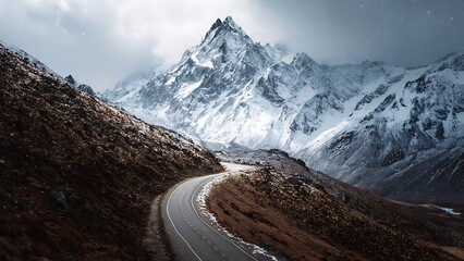 Winding Road Through Snow-Capped Mountains in Dramatic Landscape Scene