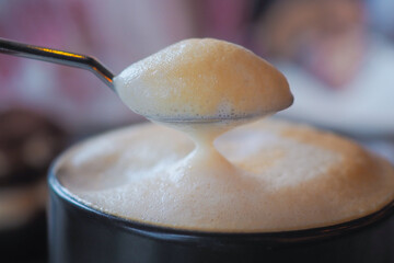 Coffee with rich, creamy foam at a cozy cafe