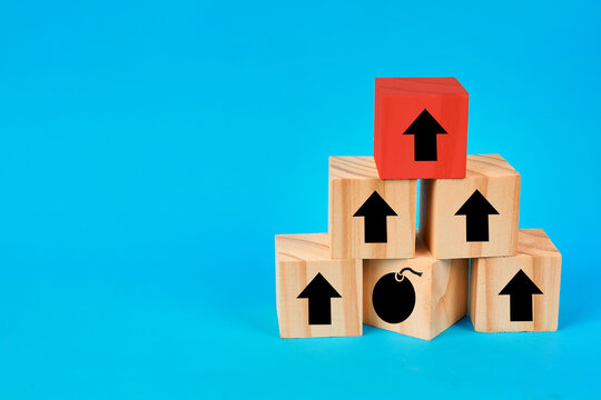 A risk and growth concept showing a pyramid of blocks with upward indicators and a danger symbol representing potential threats within progress.
