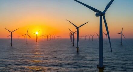 A vast array of wind turbines in an offshore wind farm at sunset, with the sun setting behind them, casting a warm orange glow over the scene.