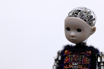 Robot doll with intricate metal components and expressive, emotive face, studio setting