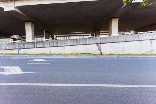 Concrete structure and asphalt road space under the overpass in the city