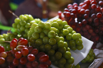 Fresh green and red grape bunch on display at market. Ripe, juicy fruit for healthy eating. vibrant and natural food background full of freshness and vitamins