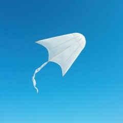 A simple white kite with a long tail flying against a clear blue sky