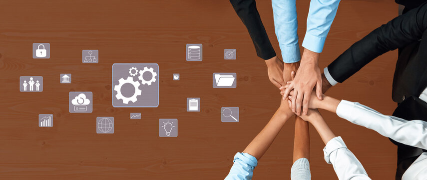 A diverse group of hands coming together over a wooden table, symbolizing teamwork and collaboration. Various business icons represent strategic planning and innovation. Trope - Powered by Adobe