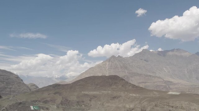 Expansive view of barren mountain ridges near Skardu with scattered clouds over a clear summer sky. Gilgit-Baltistan, Pakistan