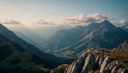 Golden sun rays shine over a stunning alpine landscape, illuminating a deep valley between towering mountain ranges