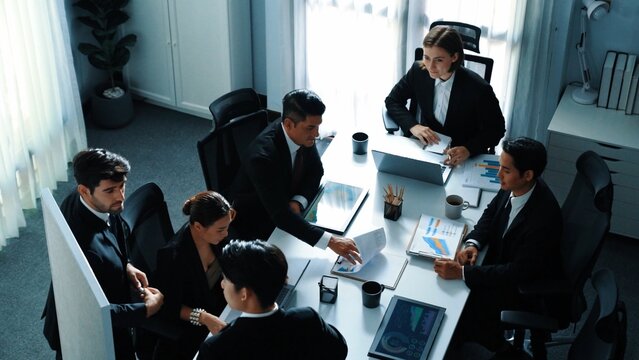 Top view of skilled project manager shake hand and invite business man to talking about marketing plan. Smart investor standing at whiteboard and analysis financial graph at meeting room. Directorate.