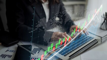 Businesswoman focused on analyzing financial data trends using a laptop, featuring graphical charts that signify growth in a modern office environment. Copula