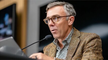 Public Speaker: An experienced speaker at a podium, captivating an audience with their words. Demonstrating confidence and clarity during a public speech