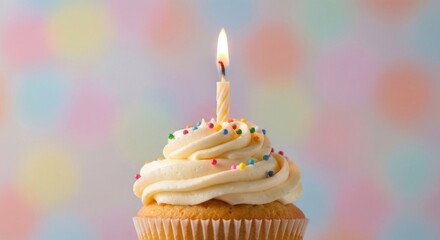 Single cupcake with a lit candle, topped with frosting and sprinkles
