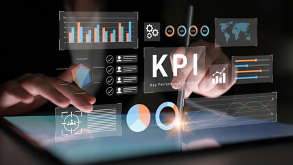 Fototapeta premium Close-up of hands using a digital tablet to explore key performance indicators with interactive graphs and charts for data-driven decision-making in business. Gantry