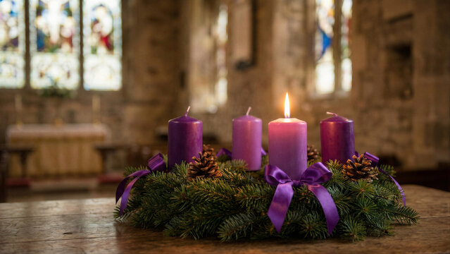 Lit Advent candle in wreath with warm spiritual atmosphere