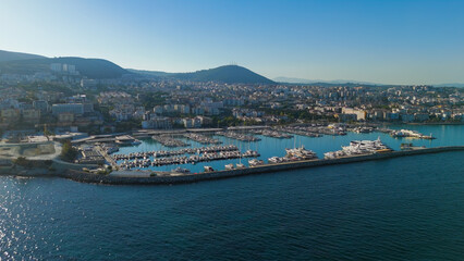 Kusadasi, Turkey. Aerial shot of Setur Marina packed with dozens of moored yachts. Summer morning view of the dense boat concentration against cityscape.. Aerial View