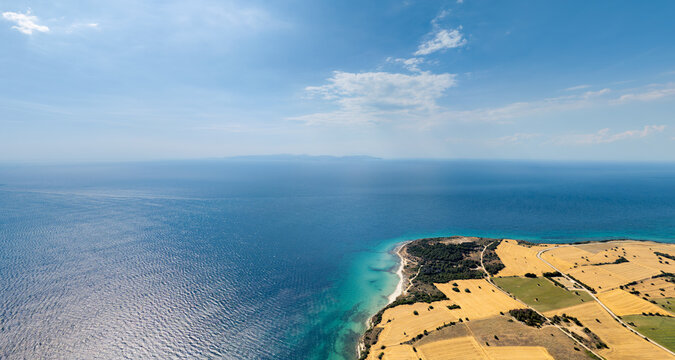 Seddulbahir, Turkey. Aerial view of Teke Cape with fields, forest and coastline on Sea of Marmara, Gokceada Island visible in haze on horizon. Aerial view