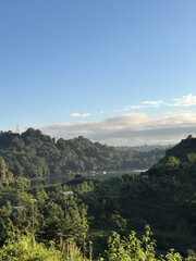 Naklejka premium Morning mountain and sea landscape with forested hills and clouds
