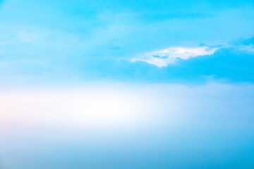 Obraz premium A bright, clear blue sky meets a glowing white horizon, suggesting a serene, open, and with sunlight of beautiful cloudy sky. landscape or abstract background. 