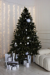 A verticalphoto of a decorated Christmas tree with gifts.