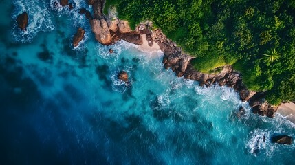 An aerial view of a tropical coastline with turquoise water, white sand beach, rocky cliffs, and lush green vegetation.