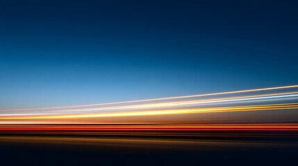 Abstract light trails at dusk across a deep blue sky conveying speed and movement