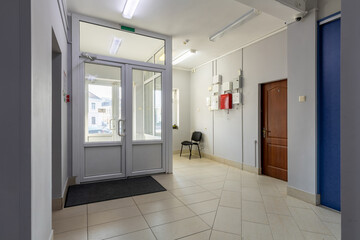 Bright Building Entrance Hall with Glass Doors and Utility Panels