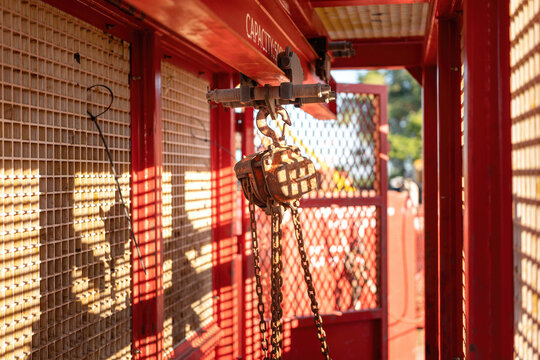 Metal pulley and hoist chain box, manual equipment using the lifting heavy object, it install on the beam of mobile toolbox. Industrial equipment object, close-up.