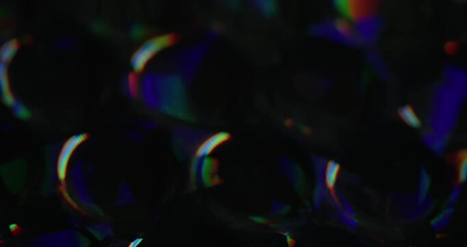Defocused glow rainbow. Colorful light. Orange blue green round reflection gleam texture leak on abstract dark black art background.