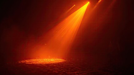 Bright orange spotlight illuminates a dusty floor with visible light beams creating a dramatic atmosphere against a dark background, evoking feelings of mystery and anticipation.