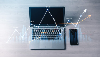 A modern laptop shows dynamic data graphs beside a smartphone, symbolizing financial analysis and strategic planning in a professional workspace. Scalp