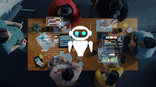 A diverse group of professionals collaborates at a wooden desk, surrounded by digital screens and chatbot graphics, illustrating modern technology in a vibrant office setting. Trope