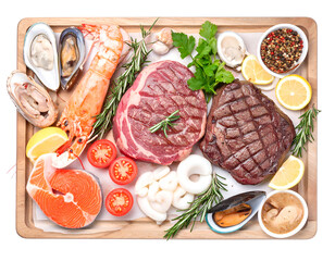 Assorted fresh seafood and grilled meats with vegetables and condiments on a wooden platter