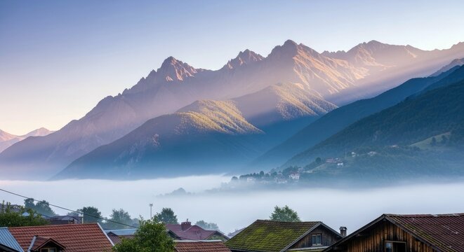 A scenic view of a mountain range with fog in the valley and a village at sunrise. - Powered by Adobe
