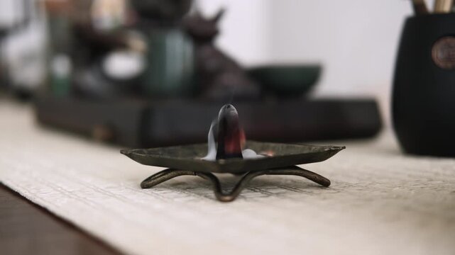 Aroma meditation. Incense burner. Religious tradition fire yoga tools with smoke smoldering on defocused calming background.