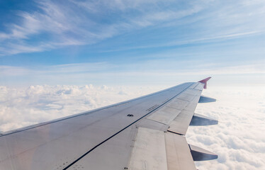 Obraz premium View from the airplane window at a beautiful cloudy sky and the airplane wing