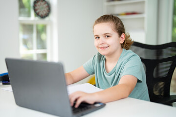 Kid using laptop for online studying at home. Child sitting at desk on virtual school lesson. Teenager learning with notebook and computer. Young student. Kids remote online class.