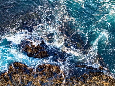 Ocean surf waves. Clear turquoise waves. Summer beach waves. Strong wave movement. Waves along dramatic coastline.