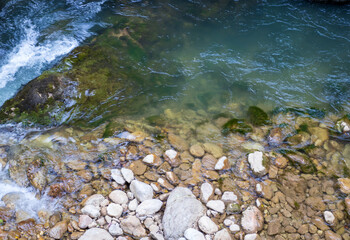 the sources of the mountain river are high in the mountains in the forest area in the summer , morning in nature
