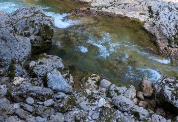 the sources of the mountain river are high in the mountains in the forest area in the summer , morning in nature