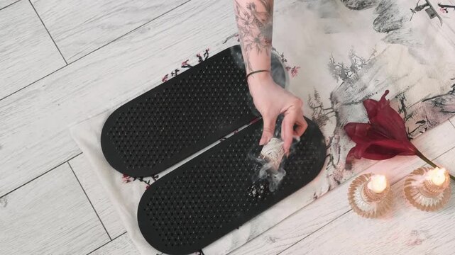 Fumigate sadhu board. Incense holder. Stick in woman hand ritual before yoga practice sharp nails on mat meditation therapy vapor fire burning candles.