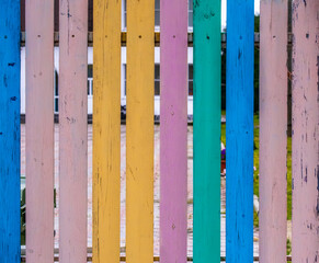 The fence is made of vertical boards of different colors.