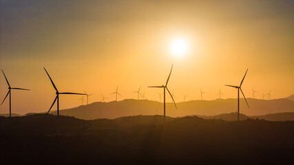 Aerial view of windmill turbines park generating green energy electric.Solar panels park and wind turbines at sunset.Green energy reduce carbon emissions and makes earth cleaner, Quang Tri, Vietnam