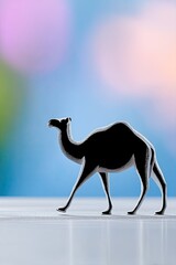 A silhouette of a camel walking on a reflective surface, set against a blurred, colorful background.