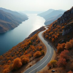 Scenic winding road through autumn mountains beside a calm river